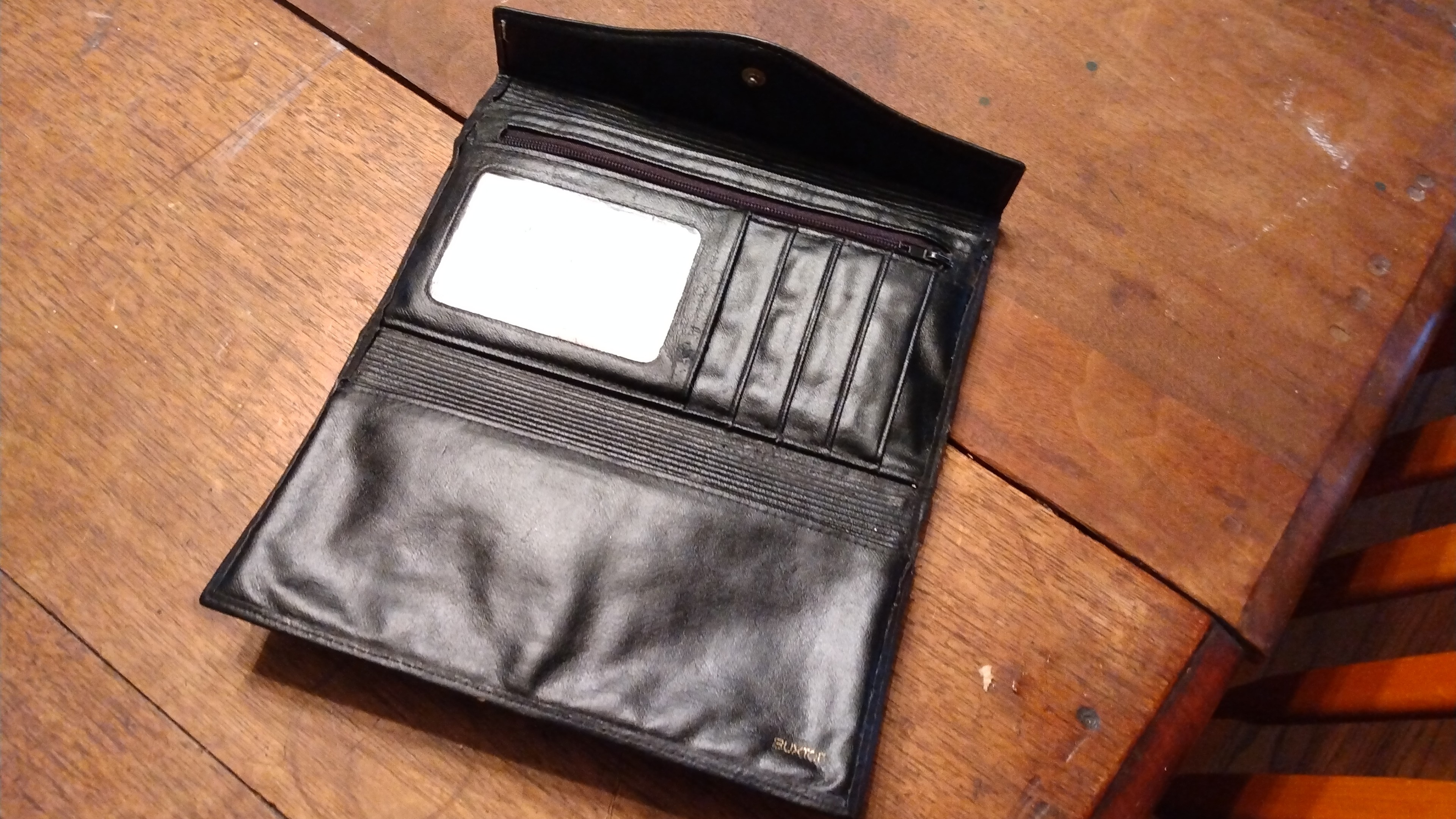 A black leather opened up. The duct tape/tin foil inserts are tucked away. The ID card holder (clear plastic) is exposed).