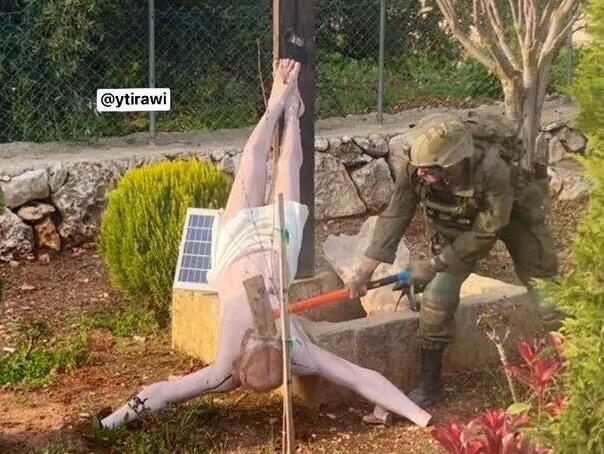 An IDF soldier smashes the head of a figure of Jesus