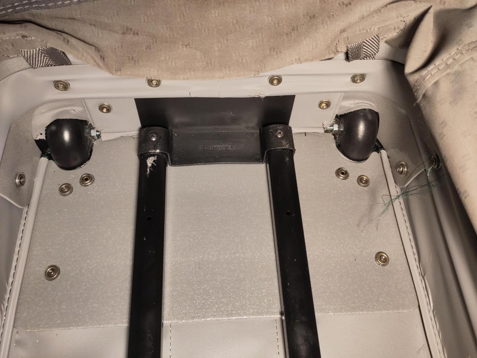 The inside of one of the suitcases. The liner is pulled out to show the frame where the new bolts are peeking through. The telescoping handle's sleeve is a bit scuffed where I had to brace the drill against it.