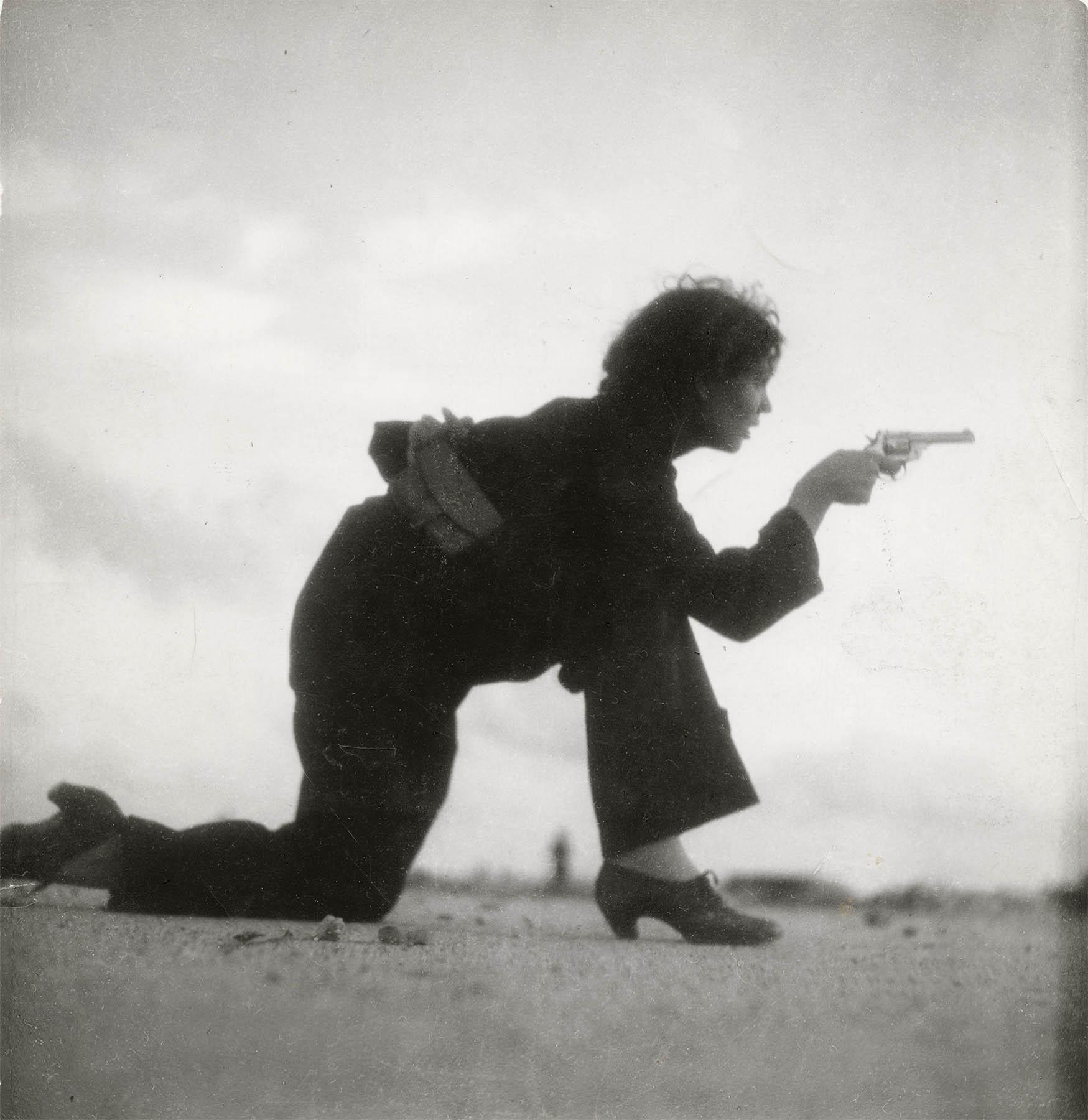 Woman training for a Republican militia is a famous photograph by German photographer Gerda Taro during the Spanish Civil War in 1936, taken on Somorrostro beach in Barcelona. The image depicts a female republican militia member on the Somorrostro beach of la Barceloneta neighborhood. She is kneeling, aiming her revolver. Her silhouette is shown against an out-of-focus background