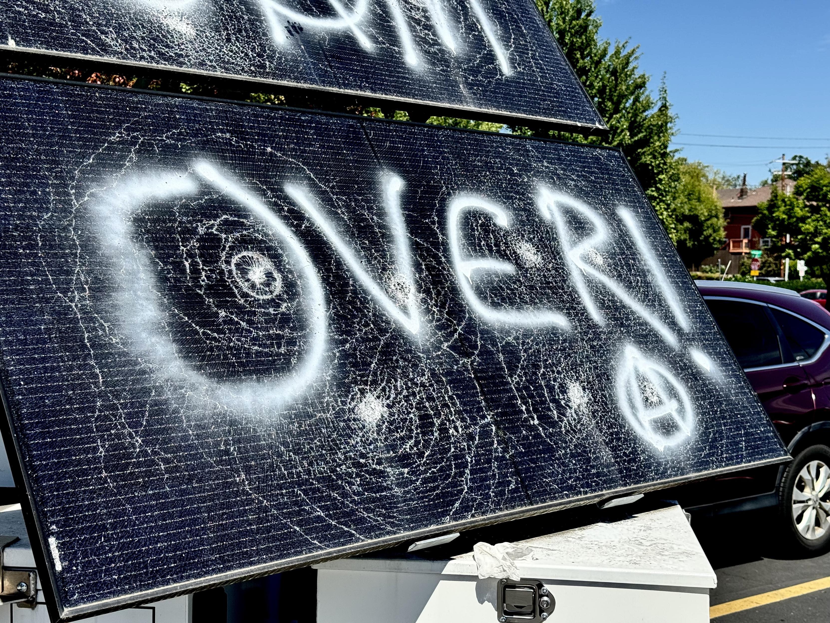 Surveillance solar panel tagged with “over” and a circle A