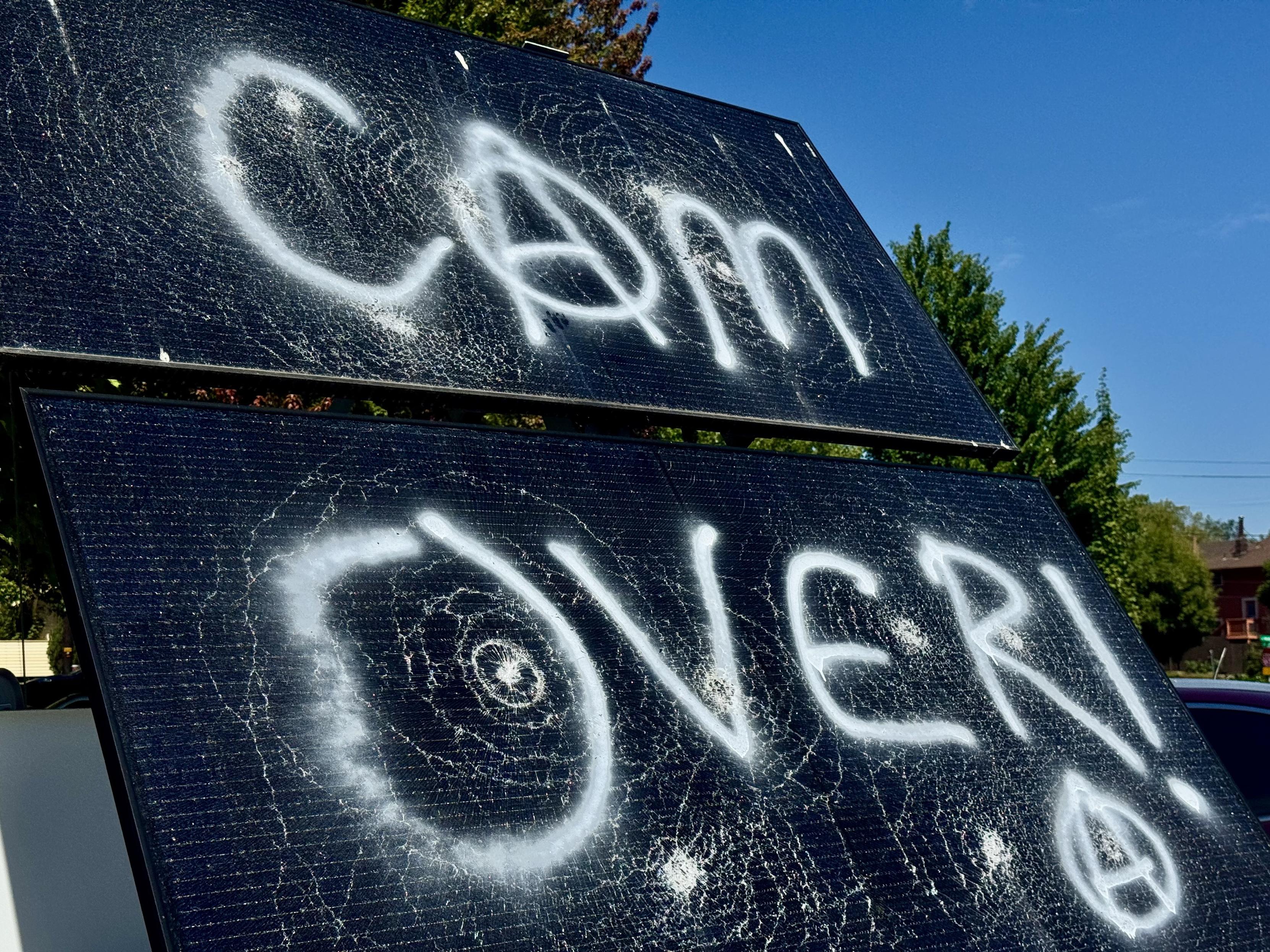 Surveillance solar panel smashed and tagged with “cam over” and a circle A